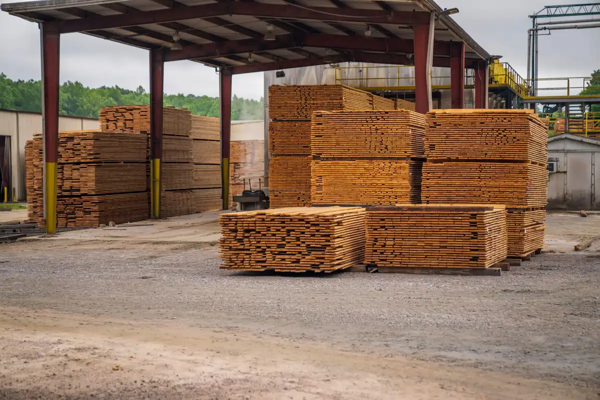 Stacks of sawn timber stored under a shed in a building materials yard