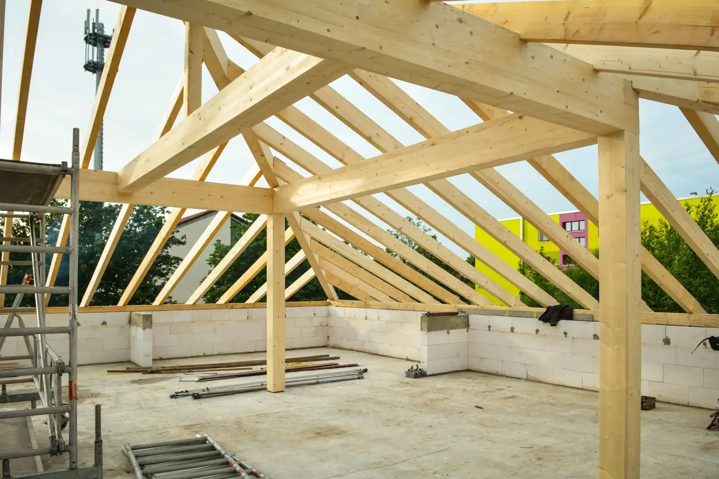 A timber roof frame going up over a concrete building