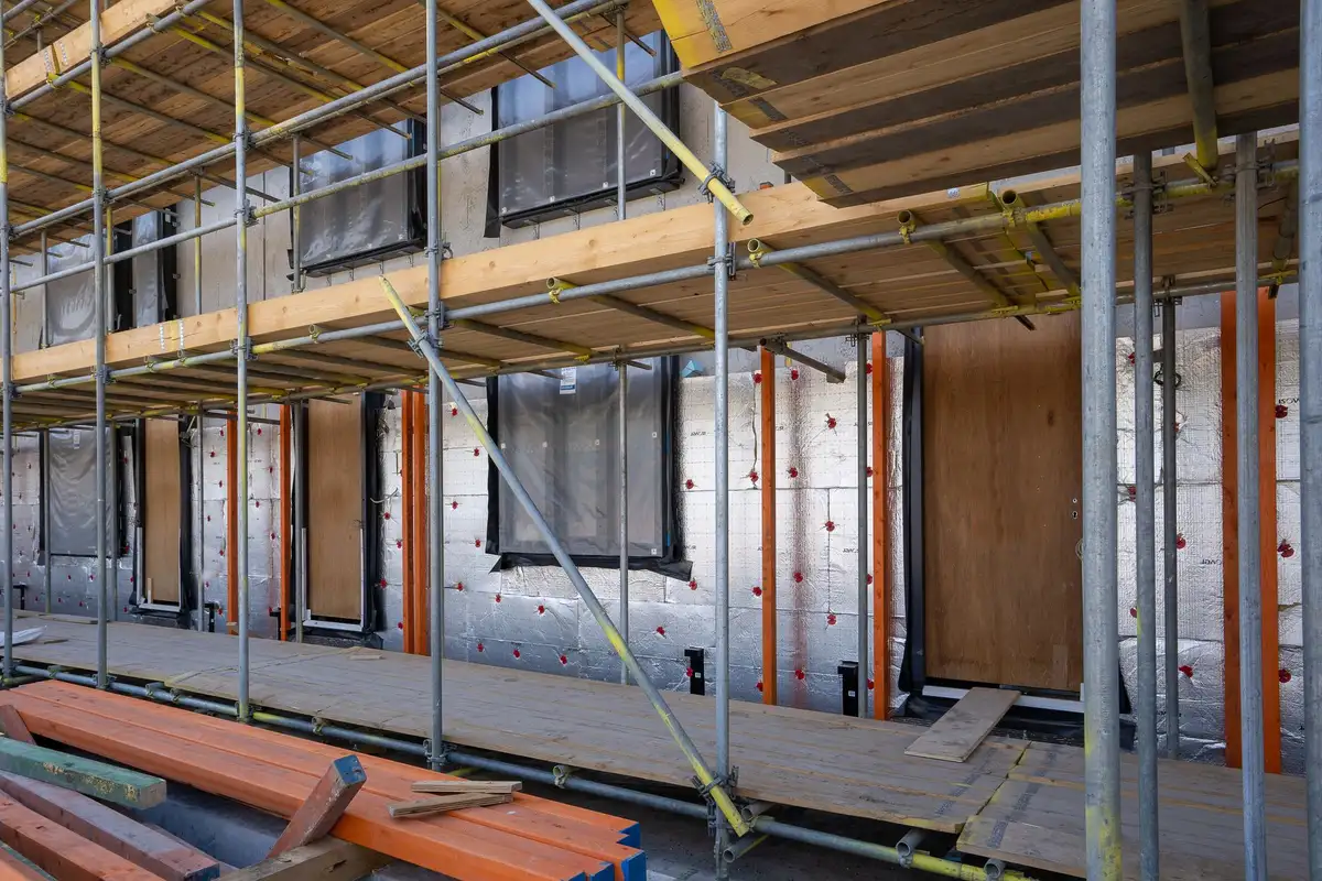 Scaffolding and timber framing along the side of a residential building under construction