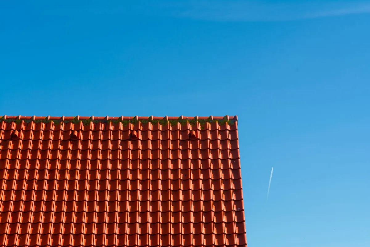 A red tiled roof against a clear blue sky
