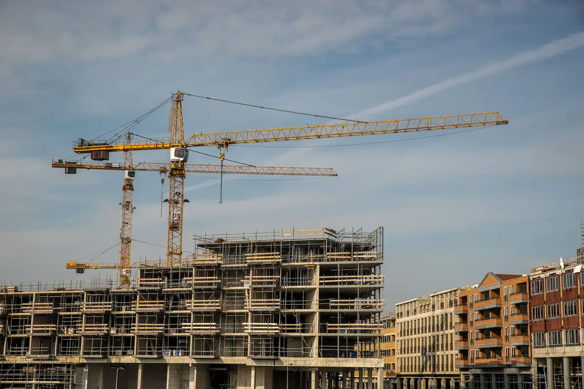 Tower cranes above a multi-storey residential building under construction