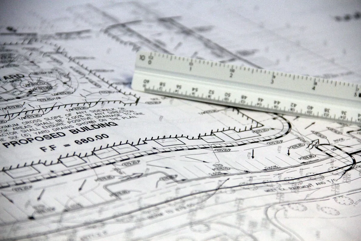 Close-up of a site plan marked "Proposed building" with a scale ruler resting on it